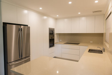 Photo of a mid-sized modern kitchen in Central Coast with an undermount sink, flat-panel cabinets, quartz benchtops, stainless steel appliances and porcelain floors.