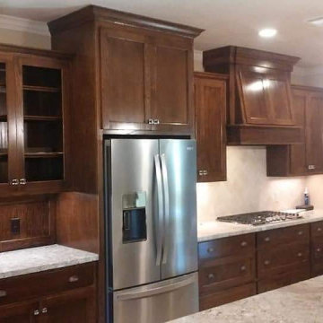 Custom Dark Stained Wood Kitchen with Glass Uppers & Built-In Fridge Enclosure