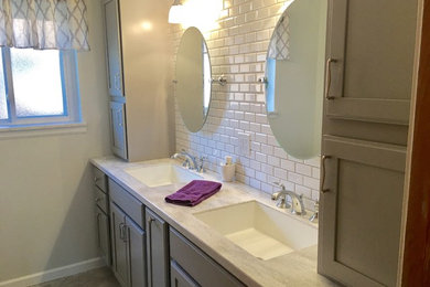 Example of a classic master bathroom design in Detroit with furniture-like cabinets, gray cabinets and solid surface countertops