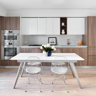 This is an example of a mid-sized contemporary eat-in kitchen in New York with a single-bowl sink, medium wood cabinets, granite benchtops, white splashback, granite splashback, stainless steel appliances, medium hardwood floors, beige floor and white benchtop.