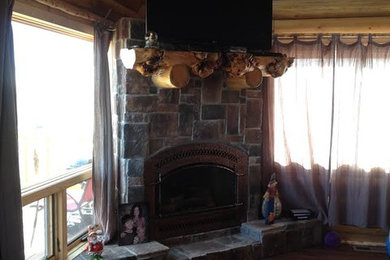 Inspiration for a mid-sized rustic open concept dark wood floor and brown floor living room remodel in Other with brown walls, a standard fireplace, a stone fireplace and a tv stand