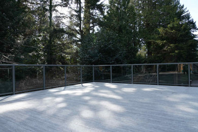 Inspiration for a mid-sized contemporary courtyard second story glass railing deck remodel in Vancouver with no cover
