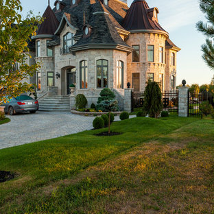 フィラデルフィアのヴィクトリアン調のおしゃれな家の外観 (石材サイディング、グレーの外壁、半切妻屋根) の写真