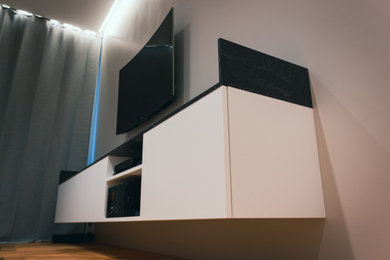 На фото: гостиная комната среднего размера в современном стиле с телевизором на стене