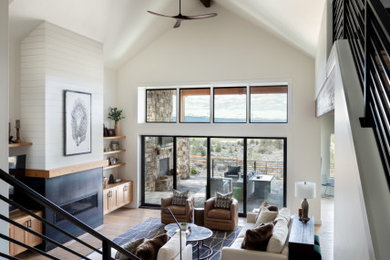 Inspiration for a huge open concept light wood floor, vaulted ceiling and shiplap wall living room remodel in Portland with white walls, a standard fireplace and a metal fireplace