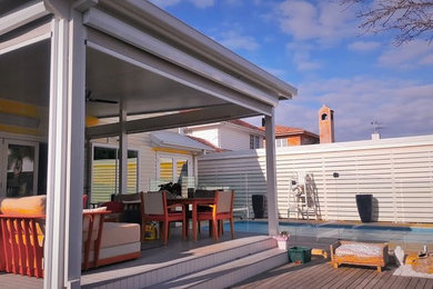 This is an example of a mid-sized modern backyard patio in Melbourne with an outdoor kitchen, decking and a roof extension.