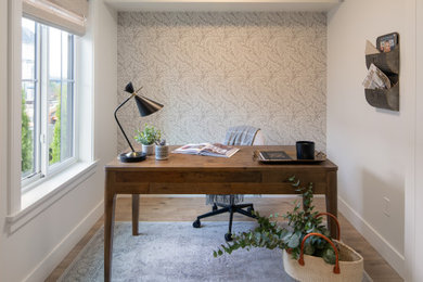 Foto de despacho de estilo de casa de campo pequeño con paredes blancas, suelo laminado, escritorio independiente y papel pintado