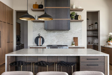 Huge trendy u-shaped medium tone wood floor and brown floor kitchen photo in Salt Lake City with flat-panel cabinets, medium tone wood cabinets, gray backsplash, stone slab backsplash, stainless steel appliances, an island and gray countertops