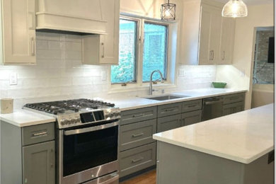 Example of a minimalist galley eat-in kitchen design in Milwaukee with a drop-in sink and an island