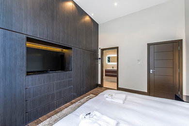 Источник вдохновения для домашнего уюта: хозяйская спальня среднего размера в современном стиле с бежевыми стенами, светлым паркетным полом и коричневым полом