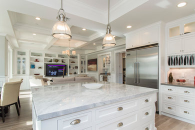 Small farmhouse u-shaped medium tone wood floor open concept kitchen photo in New York with an integrated sink, beaded inset cabinets, white cabinets, multicolored backsplash, ceramic backsplash, stainless steel appliances and an island