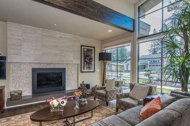 Example of a trendy medium tone wood floor family room design in Other with beige walls, a standard fireplace and a tile fireplace