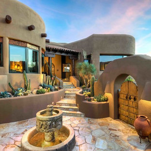 Photo of an expansive courtyard patio in Phoenix with a water feature, natural stone pavers and no cover.