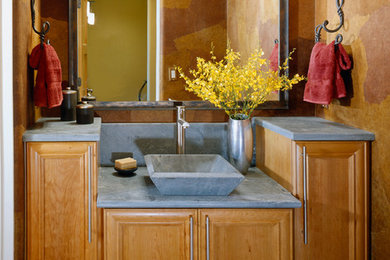 Mid-sized trendy powder room photo in Other with recessed-panel cabinets, medium tone wood cabinets, brown walls, a vessel sink, concrete countertops and gray countertops