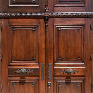 We are designers and builders of carved wood doors with wrought metal appliqués.