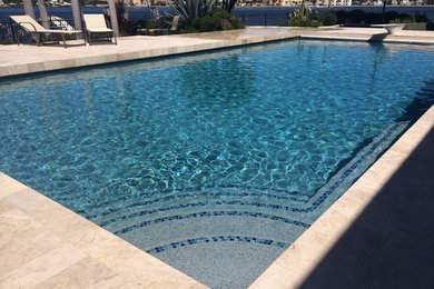 Large transitional backyard rectangular lap pool in Miami with tile.