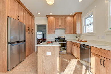 Inspiration for a mid-sized galley kitchen remodel in Chicago with an undermount sink, shaker cabinets, light wood cabinets, quartzite countertops, stainless steel appliances, an island and beige countertops