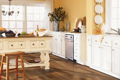 Inspiration for a timeless single-wall light wood floor kitchen remodel in New York with a drop-in sink, recessed-panel cabinets, white cabinets, stainless steel appliances, an island and granite countertops
