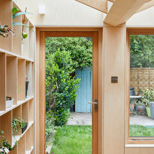 ロンドンのモダンスタイルのおしゃれな家事室 (オープンシェルフ、淡色木目調キャビネット、人工大理石カウンター、無垢フローリング、目隠し付き洗濯機・乾燥機、茶色い床、黄色いキッチンカウンター) の写真