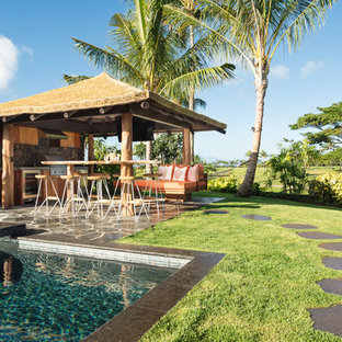 ハワイの大きいトロピカルスタイルのおしゃれな裏庭のテラス (アウトドアキッチン、天然石敷き、ガゼボ・カバナ) の写真