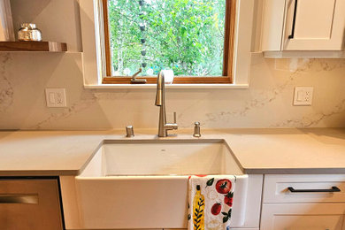 Eat-in kitchen - transitional eat-in kitchen idea in Seattle with a farmhouse sink, shaker cabinets, quartz countertops, stainless steel appliances and an island