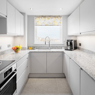This is an example of a small contemporary u-shaped enclosed kitchen in Sussex with a submerged sink, flat-panel cabinets, grey cabinets, quartz worktops, integrated appliances, porcelain flooring, no island, grey floors and multicoloured worktops.