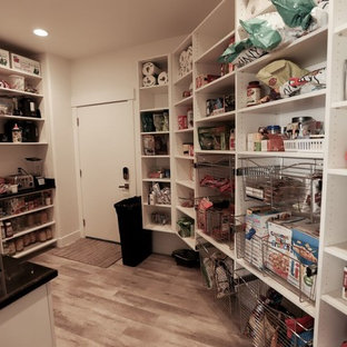 Inspiration för ett stort lantligt svart svart kök, med en undermonterad diskho, släta luckor, vita skåp, bänkskiva i kvarts, rostfria vitvaror, ljust trägolv och beiget golv