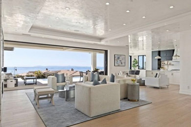 Living room - large contemporary open concept light wood floor and beige floor living room idea in Orange County with white walls, a standard fireplace, a stacked stone fireplace and a wall-mounted tv