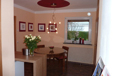Exempel på en liten modern matplats med öppen planlösning, med gula väggar och målat trägolv