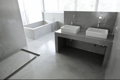 Foto de cuarto de baño doble y a medida urbano con puertas de armario blancas, bañera encastrada, ducha a ras de suelo, encimera de cemento, ducha con puerta corredera y encimeras grises