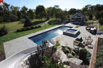 Large contemporary backyard rectangular lap pool in Philadelphia with a water slide.