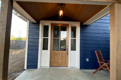 Entryway - mid-sized coastal entryway idea in Other with a brown front door
