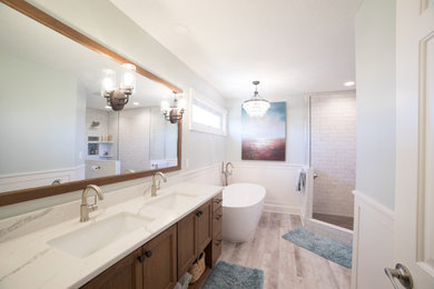 Example of a large trendy master multicolored tile and subway tile ceramic tile and multicolored floor bathroom design in Other with recessed-panel cabinets, medium tone wood cabinets, a one-piece toilet, blue walls, an undermount sink and marble countertops