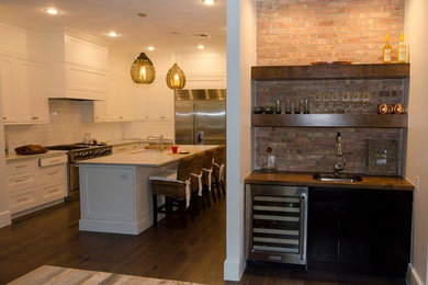 Mid-sized transitional u-shaped dark wood floor open concept kitchen photo in Austin with an undermount sink, recessed-panel cabinets, white cabinets, marble countertops, white backsplash, ceramic backsplash, stainless steel appliances and an island