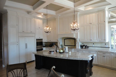 This is an example of a large transitional l-shaped eat-in kitchen in Tampa with raised-panel cabinets, white cabinets, granite benchtops, beige splashback, ceramic splashback, stainless steel appliances, travertine floors and with island.