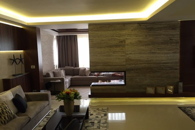 Large minimalist formal and open concept ceramic tile living room photo in Other with beige walls, a two-sided fireplace, a stone fireplace and a wall-mounted tv