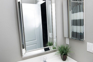 Example of a small transitional 3/4 alcove shower design in San Diego with raised-panel cabinets, white cabinets, gray walls, a drop-in sink and quartz countertops