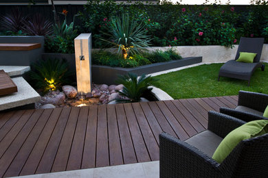 This is an example of a small traditional backyard garden in Perth with a water feature and decking.