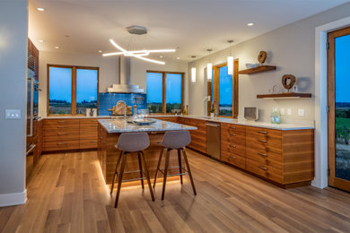 Inspiration for a large modern u-shaped light wood floor open concept kitchen remodel in Other with an undermount sink, flat-panel cabinets, medium tone wood cabinets, quartz countertops, blue backsplash, glass tile backsplash, stainless steel appliances, an island and white countertops