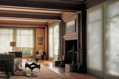 Medium tone wood floor living room photo in Omaha with brown walls, a standard fireplace and a wood fireplace surround