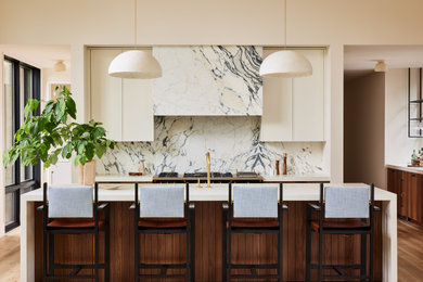 Inspiration for a huge contemporary u-shaped light wood floor and vaulted ceiling open concept kitchen remodel in Grand Rapids with an undermount sink, flat-panel cabinets, medium tone wood cabinets, stone slab backsplash, paneled appliances, an island and white countertops