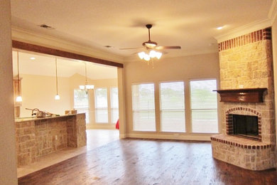 Example of a mid-sized transitional open concept medium tone wood floor family room design in Dallas with beige walls, a corner fireplace and a stone fireplace