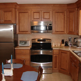 Создайте стильный интерьер: маленькая угловая, отдельная кухня в классическом стиле с фасадами с выступающей филенкой, фасадами цвета дерева среднего тона, столешницей из ламината, бежевым фартуком, техникой из нержавеющей стали, накладной раковиной и полом из линолеума без острова - последний тренд