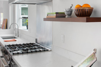Example of a trendy galley kitchen design in Santa Barbara with gray cabinets, stainless steel appliances and white countertops