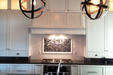 Mid-sized transitional u-shaped eat-in kitchen photo in Seattle with recessed-panel cabinets, white cabinets, granite countertops, white backsplash, subway tile backsplash, stainless steel appliances and an island