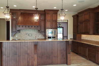 Eat-in kitchen - large traditional u-shaped eat-in kitchen idea in Other with an undermount sink, raised-panel cabinets, dark wood cabinets, granite countertops, beige backsplash, ceramic backsplash, stainless steel appliances and an island