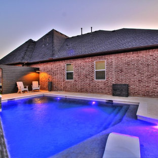 Modelo de piscina moderna, de tamaño medio, rectangular, en patio trasero, con adoquines de piedra natural