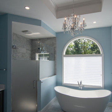Traditional master bath utilizing frosted and clear glass to allow for needed pr