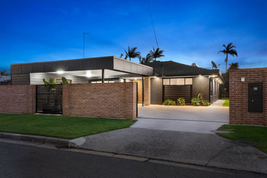 Inspiration for a mid-sized contemporary one-storey grey house exterior in Gold Coast - Tweed with mixed siding, a flat roof and a mixed roof.