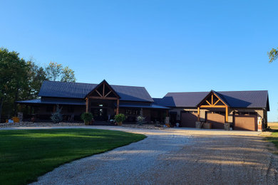 Inspiration for a large cottage brown two-story metal and board and batten house exterior remodel in Kansas City with a metal roof and a black roof
